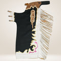 Decorative horse saddle blanket with intricate patterns and fringes on a light background