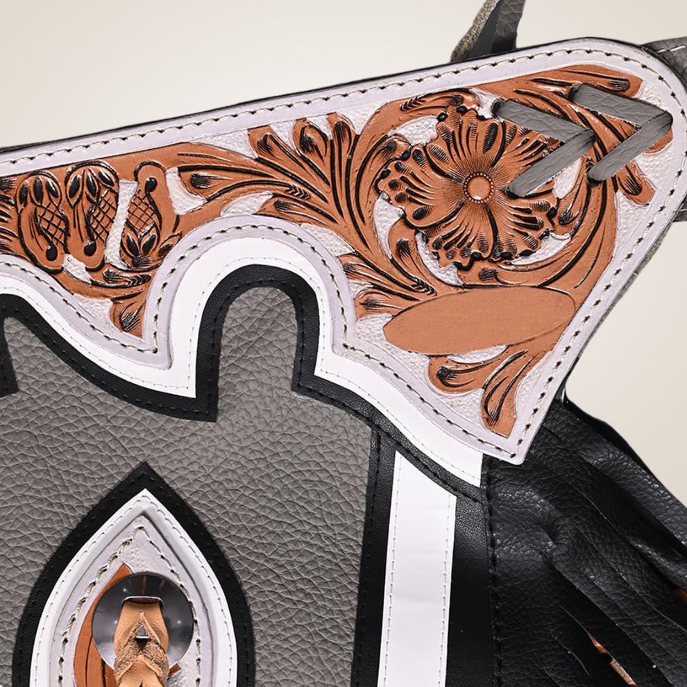 Close-up of a leather product with intricate tooled design on a beige background