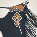 Black top with orange cross design and white fringe on a beige background