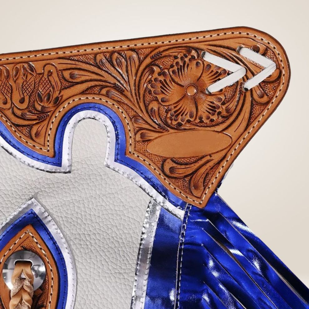 Close-up of a leather boot with intricate tooled design and blue accents on a beige background