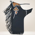 Black fringe rodeo chaps with decorative cross and embroidery on a beige background