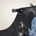 Black leather apron with decorative elements on a neutral background