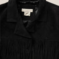 Black jacket with a brand label on a beige background