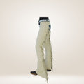 White bell-bottom pants with fringe details on a light gray background