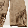 Close-up of brown suede pants with fringes on a light beige background