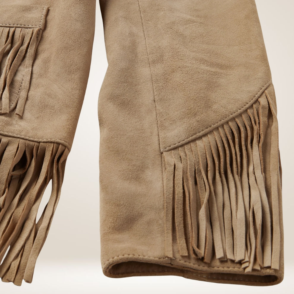 Close-up of brown suede pants with fringes on a light beige background