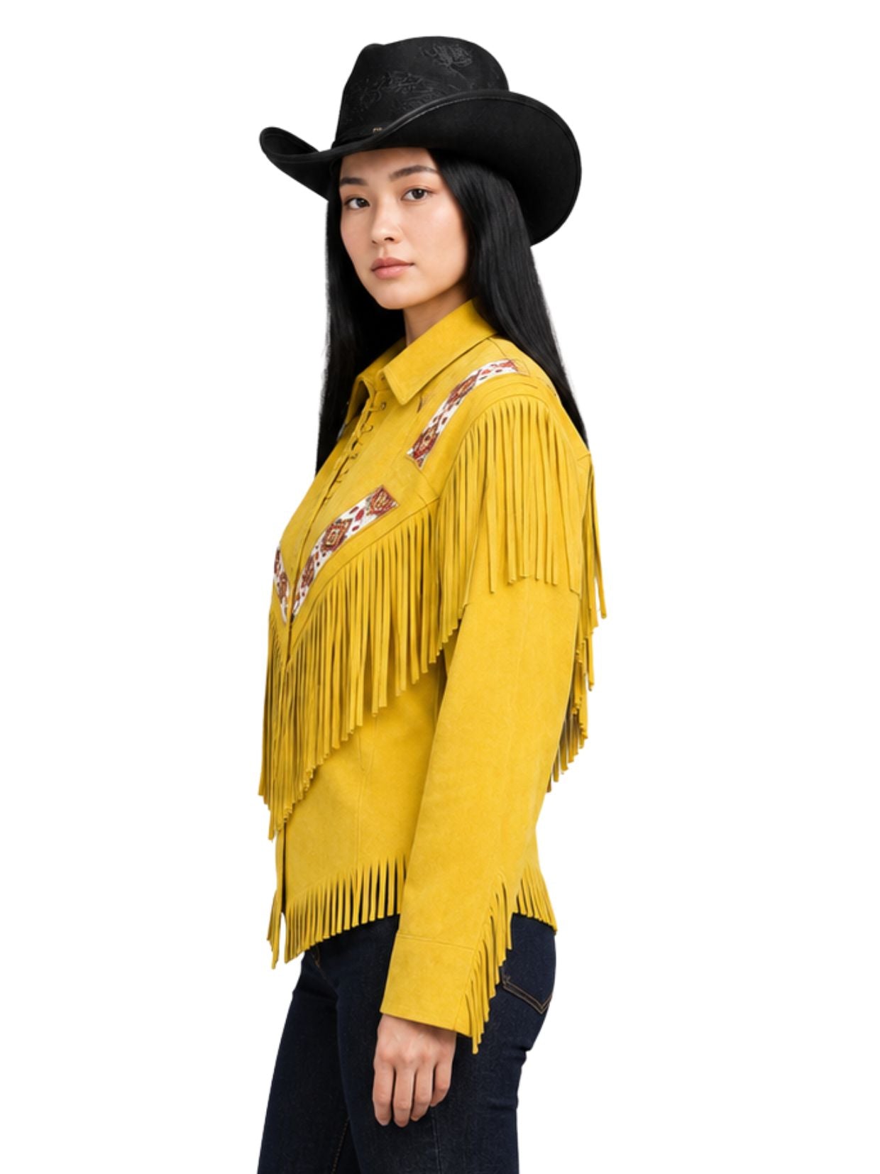 Woman wearing a yellow fringed shirt with embroidery and a black cowboy hat on a white background