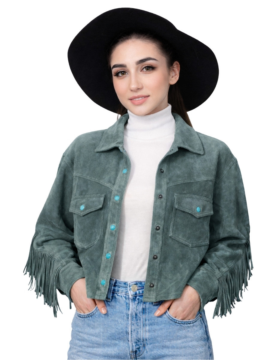 Woman wearing a green suede jacket with fringe, white turtleneck, and blue jeans on a white background